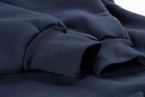Close-up of navy hoodie fabric with ribbed cuffs and soft sweatshirt material texture