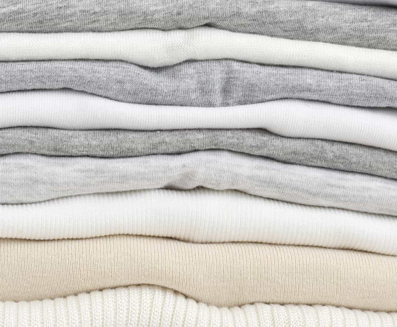Stacked soft cotton knit fabrics in neutral white and gray shades