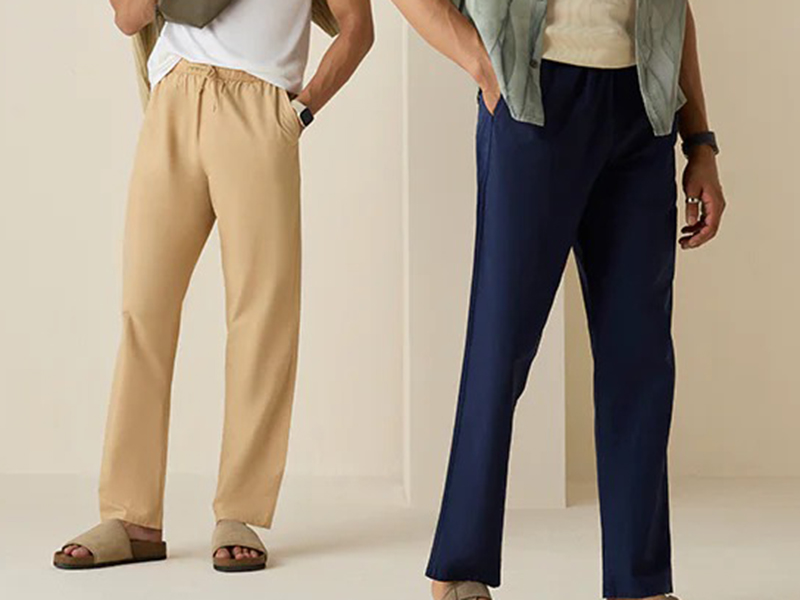 Two men wearing relaxed lounge pants in beige and navy with straight-leg fit.