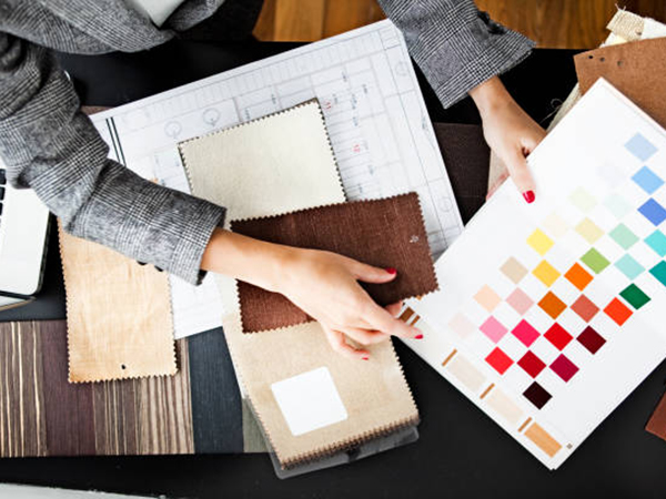 Designer selecting fabric swatches and color palette for textile production planning