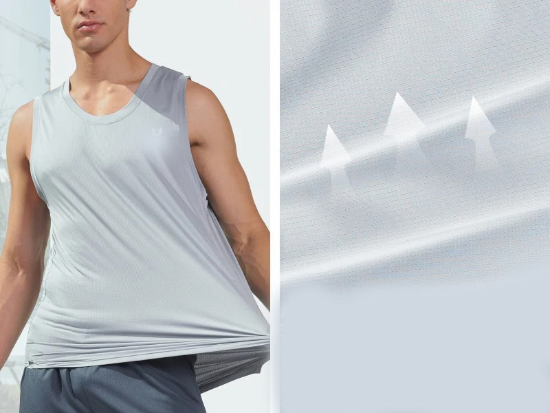 Man wearing a light gray athletic sleeveless tank top, demonstrating its stretchy fabric by pulling it slightly away from his body.