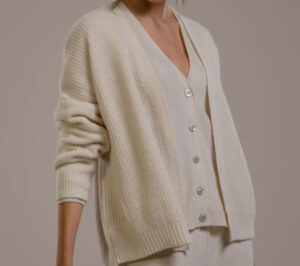 Woman wearing soft cream knit cardigan sweater with relaxed elegant casual fit