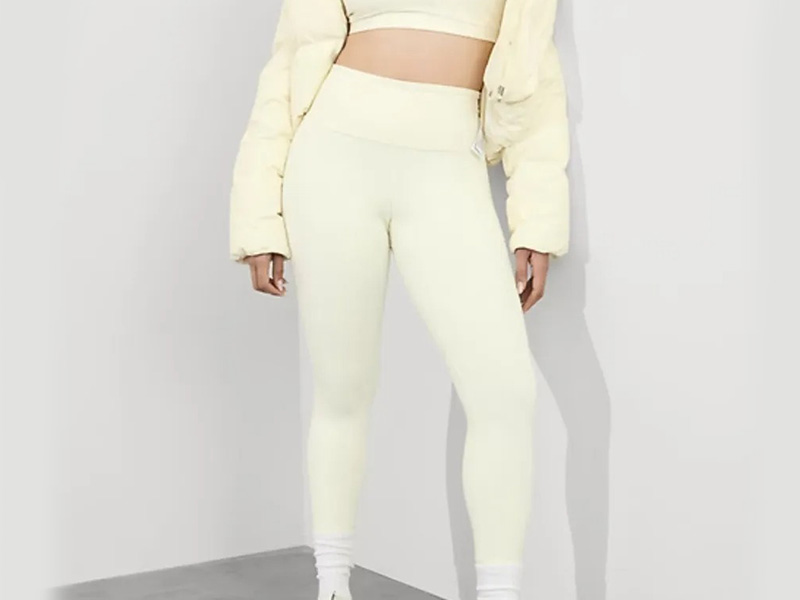 Woman wearing cream high-waisted leggings and matching activewear set, designed for yoga, workouts, and everyday athleisure comfort.