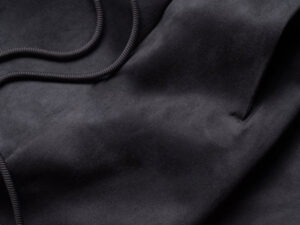 Close-up of black fleece sweatpants fabric showing soft texture and drawstring detail.