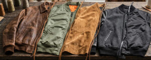 Assortment of bomber jackets made from leather, nylon, suede, and wool fabrics displayed side by side, showcasing different textures, linings, and material options for classic outerwear.