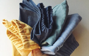 Hand holding various colors of folded elastic waist shorts
