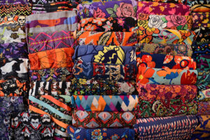 Various colorful leggings with bold patterns stacked together on display