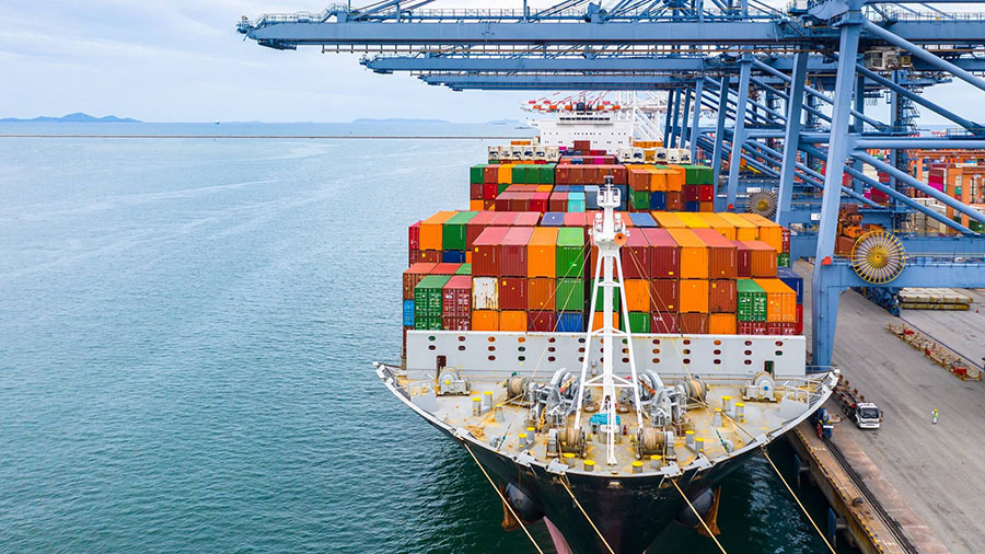 Large container ship docked at port loading cargo containers cranes