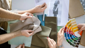 Designers comparing fabric swatches and color palettes for apparel development and textile selection.