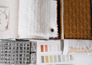 Assorted fabric swatches of various textures and colors laid out on a table.