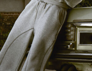 Close-up view of gray sweatpants showing stitched seams and waistband details.