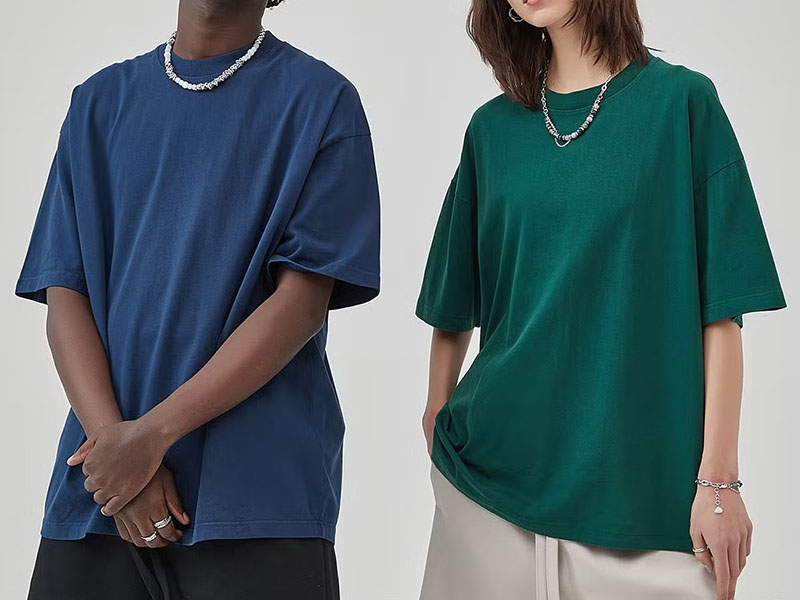 Two models wearing oversized heavyweight cotton T-shirts in blue and green.