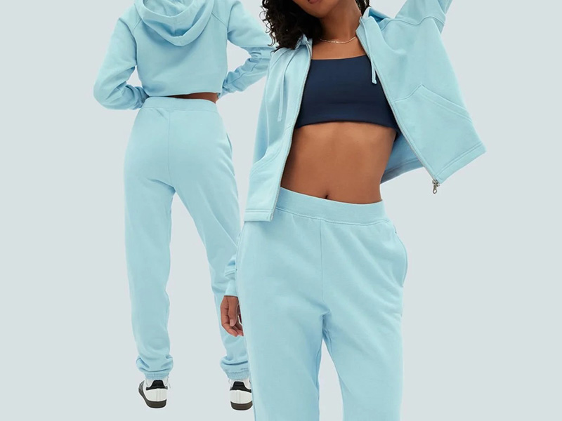 Woman wearing a sky blue hoodie and jogger set, styled with a sports bra for casual comfort and athleisure fashion.