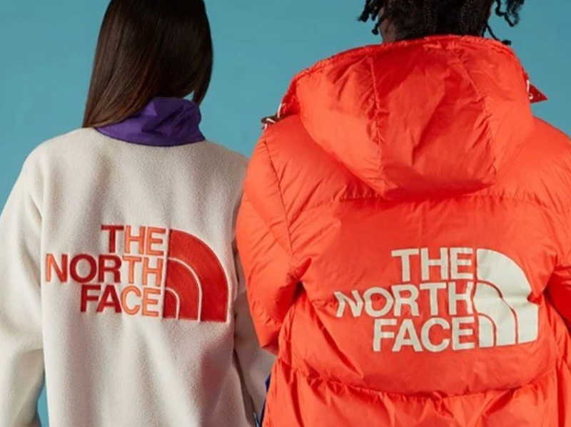 Two people wearing The North Face fleece and puffer jackets.