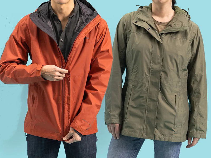 Close-up of two lightweight waterproof raincoats, one orange and one olive green, worn by models