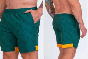 Front and back views of men's green shorts with black print and yellow trim.