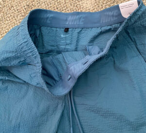 Close-up of lightweight running shorts featuring elastic waistband, breathable liner, moisture-wicking fabric, and adjustable drawstring for athletic comfort and performance.