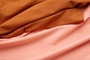 Close-up of brown and pink knit fabric showcasing smooth texture and draped folds
