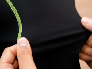 Close-up of black workout fabric being stretched by two hands showing elasticity