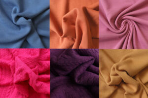 Assorted textured knit fabrics in vibrant colors, showcasing waffle, quilted, and patterned weaves for apparel and textile design applications.