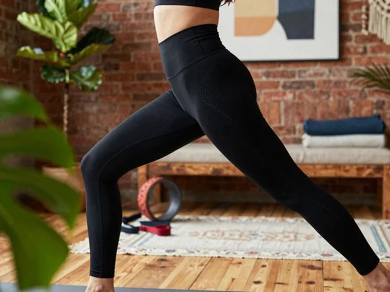 Woman wearing black high-waisted leggings during yoga workout, featuring stretchy performance fabric for fitness, training, and active lifestyles.