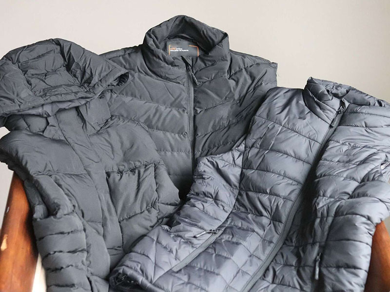 Collection of gray lightweight puffer jackets with quilted insulation and zippered fronts displayed together indoors.