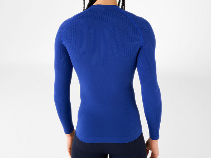 Back view of a blue long-sleeve compression shirt featuring seamless construction, ergonomic fit, and moisture-wicking performance fabric for athletic training.