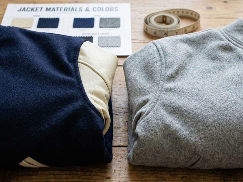 Folded wool and fleece jacket fabrics with color swatches and measuring tape, highlighting material textures, warmth, and outerwear design options.