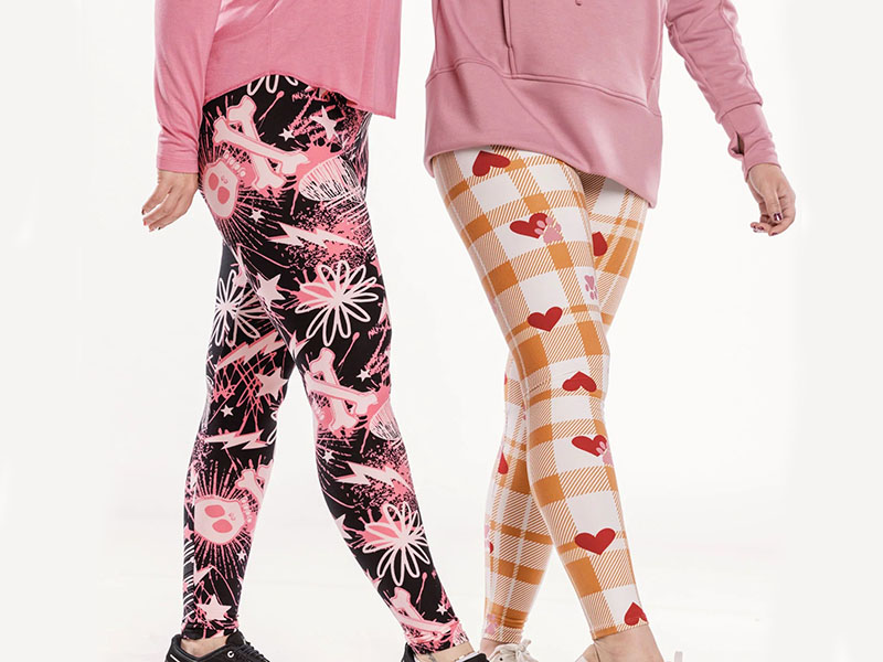 Two people wearing bright patterned leggings with hearts and graphic designs.