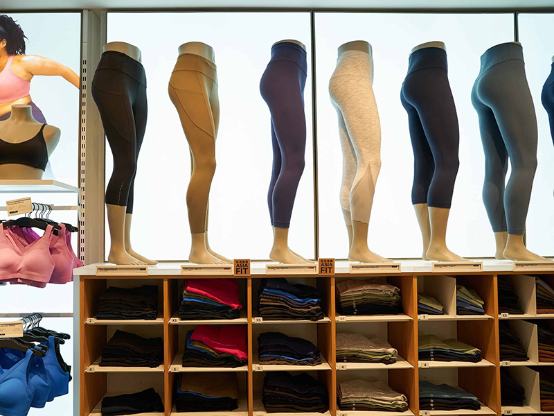 Mannequins displaying colorful women’s leggings and activewear inside a modern retail store.