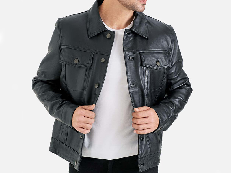 Man wearing black leather jacket over white shirt with modern casual biker-inspired fashion style and structured fit.