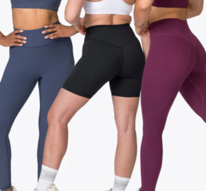 Three women wearing high-waisted leggings and biker shorts in black, navy, and purple for fitness and activewear.